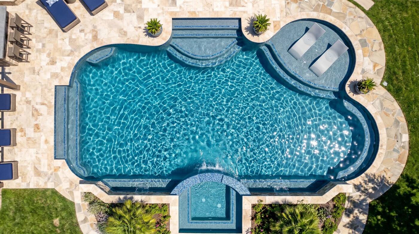 Aerial view of a clear backyard pool maintained by Escape Pool Services
